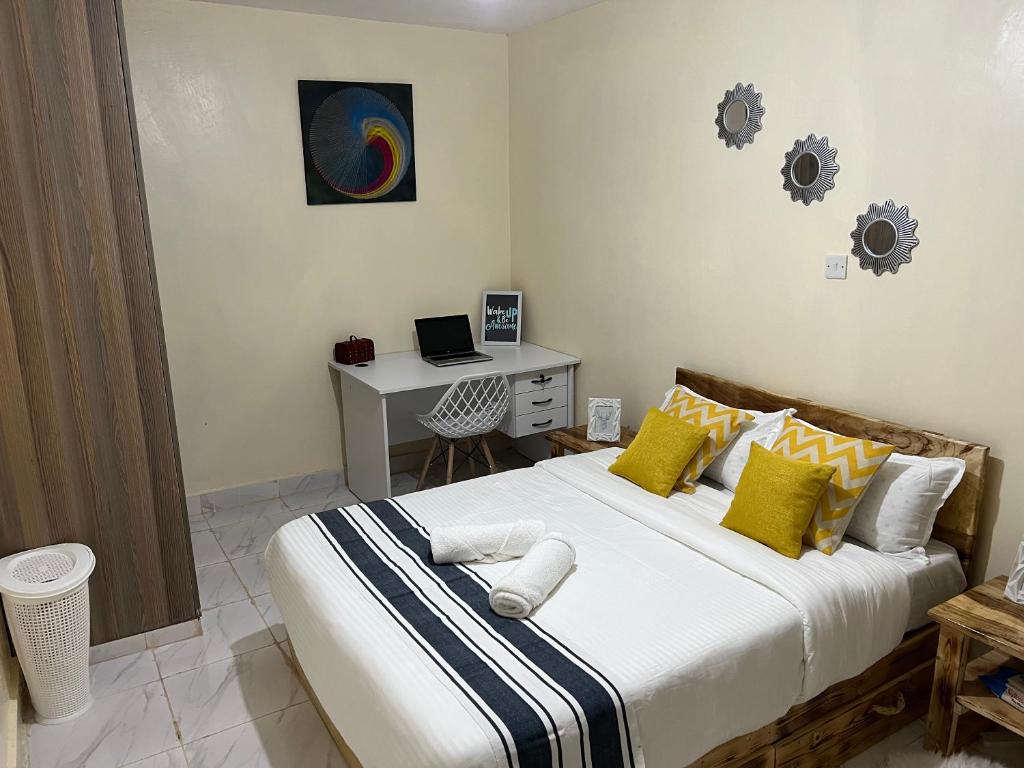 尼耶利Ruby Modern Homes-2br-Nyeri, King'ong'o-Knights的一间卧室配有一张带黄色和白色枕头的大床
