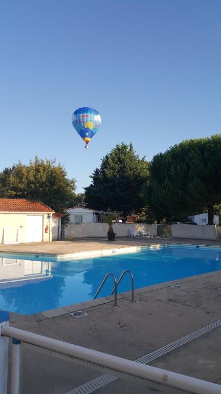 SireuilCamping du Nizour的飞过游泳池的热气球