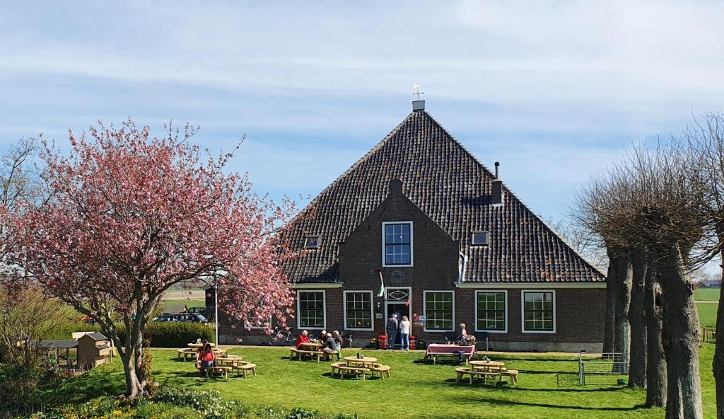 NoordbeemsterVakantieboerderij Huize Nuis的一座大房子,前面有人