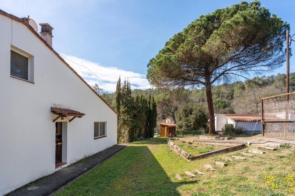 赫罗纳Casa con piscina cerca de Girona的享有白色房子庭院的景色