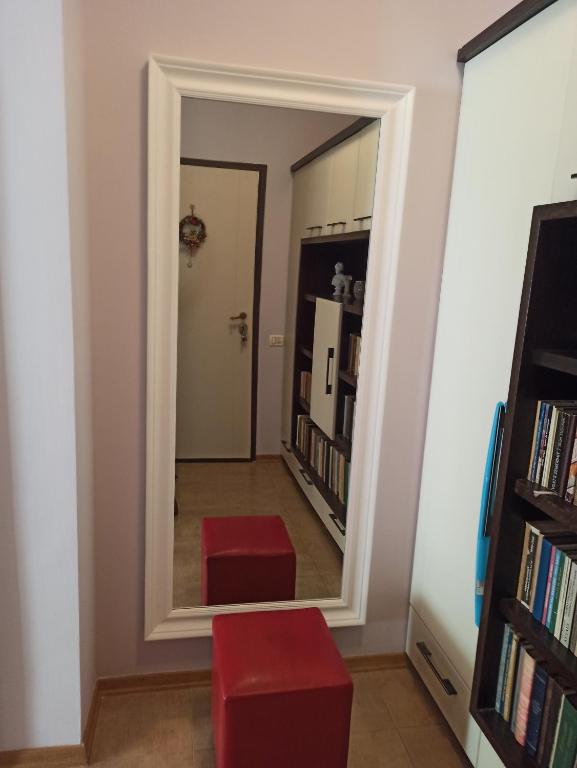地拉那Home Sweet Rental的走廊上的镜子,有两把红色凳子