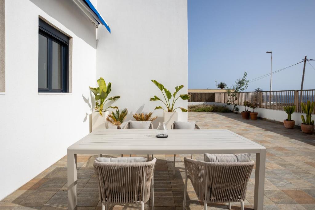 厄尔梅达诺Villa Arizona - 3-bedroom house by the sea的庭院里的白色桌椅