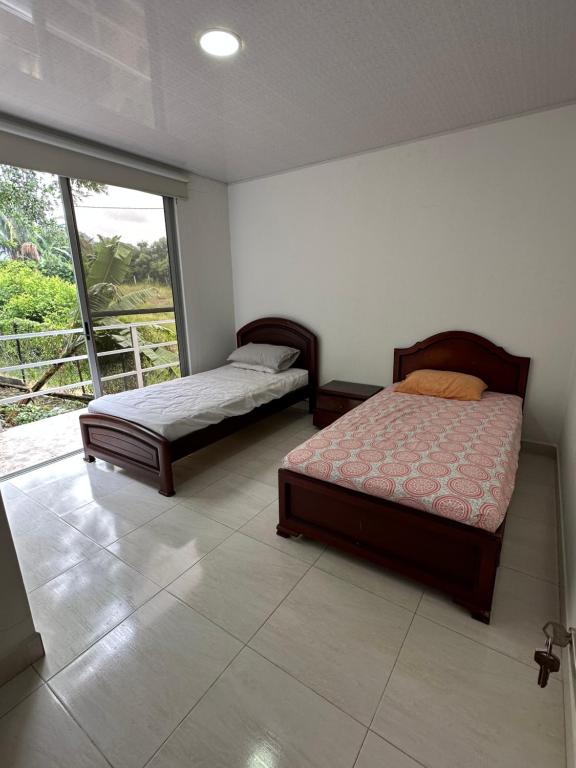 拉米萨Casa campestre Buenavista - La Mesa的一间卧室设有两张床和大窗户