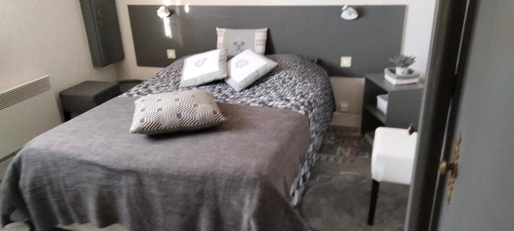 Saint-Vigor-le-GrandLes Mimosas的一间卧室配有一张带两个枕头的床