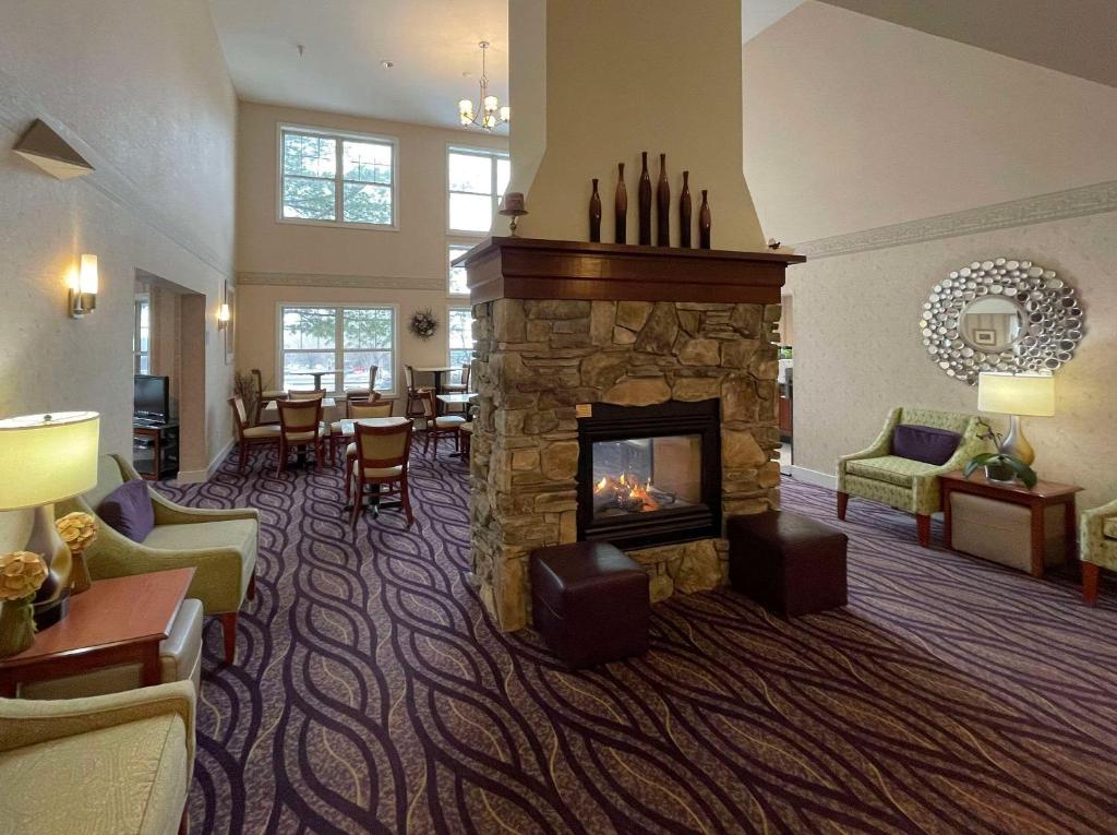 伯灵顿Smart Suites, Ascend Hotel Collection的带壁炉的客厅位于酒店客房内