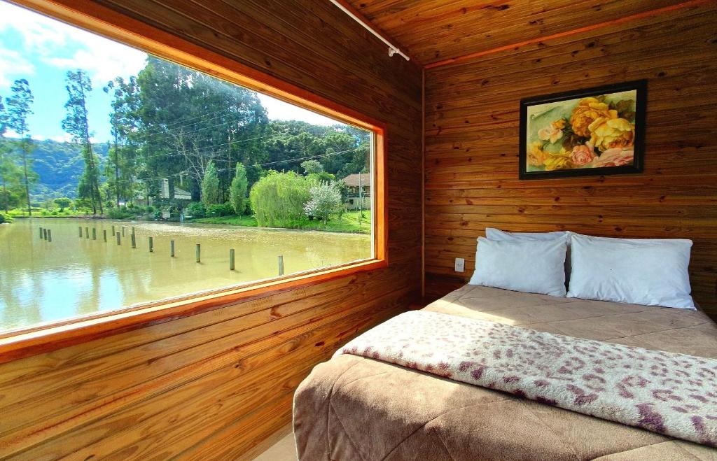 乌鲁比西Pousada Mato Verde - Urubici - SC的卧室设有大窗户和一张床