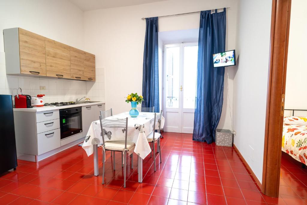 罗卡迪帕帕L'Orizzonte House-Rocca Di Papa Centro的厨房铺有红色瓷砖地板,配有桌椅