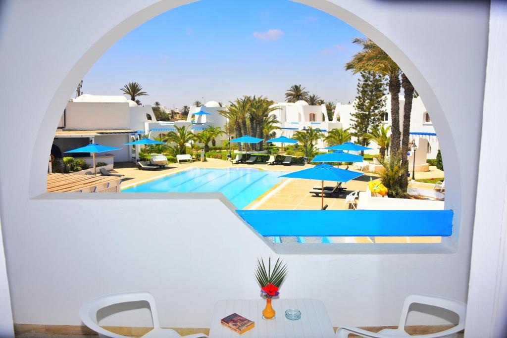米多恩Zenon Djerba的从度假村的窗户可欣赏到游泳池的景色