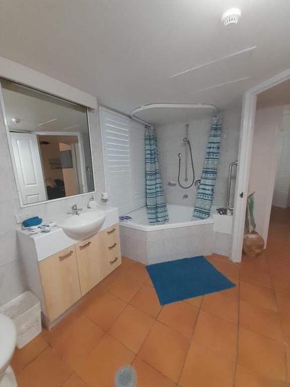 凯恩斯Casa Borghese Holiday Let的浴室配有水槽、淋浴和浴缸。