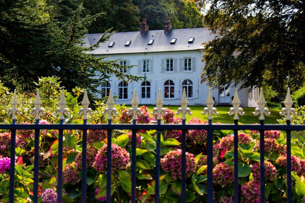 索姆河畔的圣瓦列里罗马尔城堡旅馆 - 百德索姆河德的白色房子前面的围栏,花朵