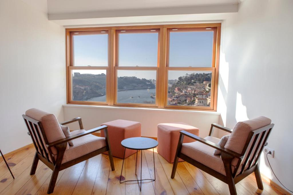 波尔图杜罗美景城市休闲公寓的带三把椅子、一张桌子和一扇窗户的房间