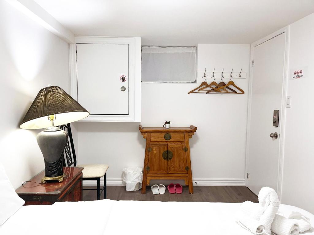 多伦多Simple & Tidy Private Rooms的一间卧室配有一张床、一盏灯和一把椅子