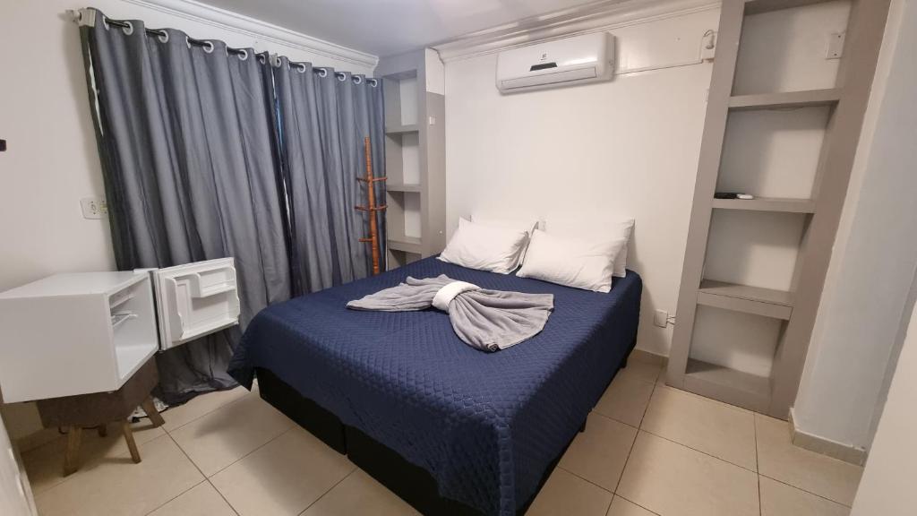 卡波布里奥Zênit Hostel da Cris的一间卧室配有一张带蓝色棉被的床