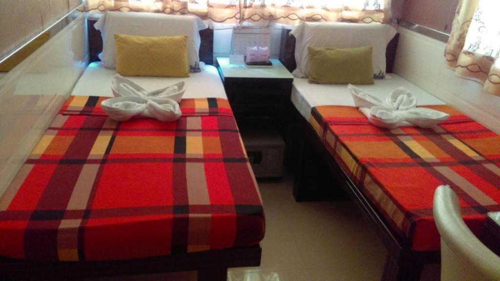 香港London Guest House的红色和条纹的客房内的两张单人床