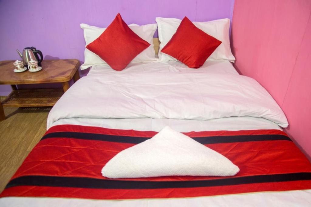 NātangHill Home Stay, Baichung的一张带红色和白色枕头的床