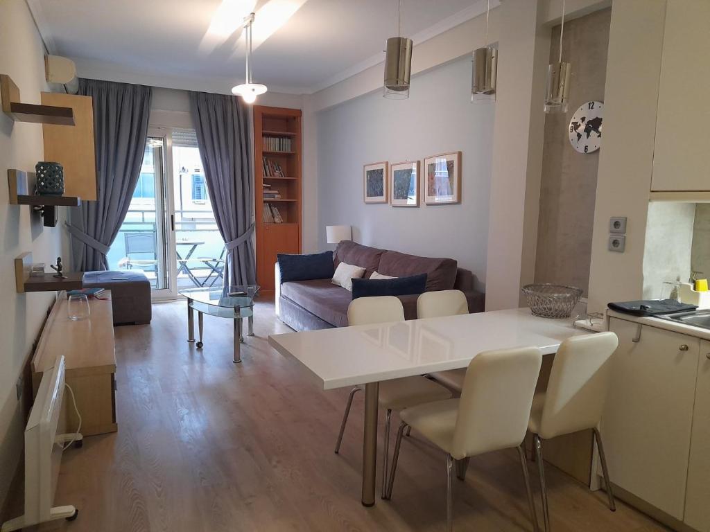 塞萨洛尼基Luxury Apartment Philoxenia的厨房以及带白色桌椅的起居室。
