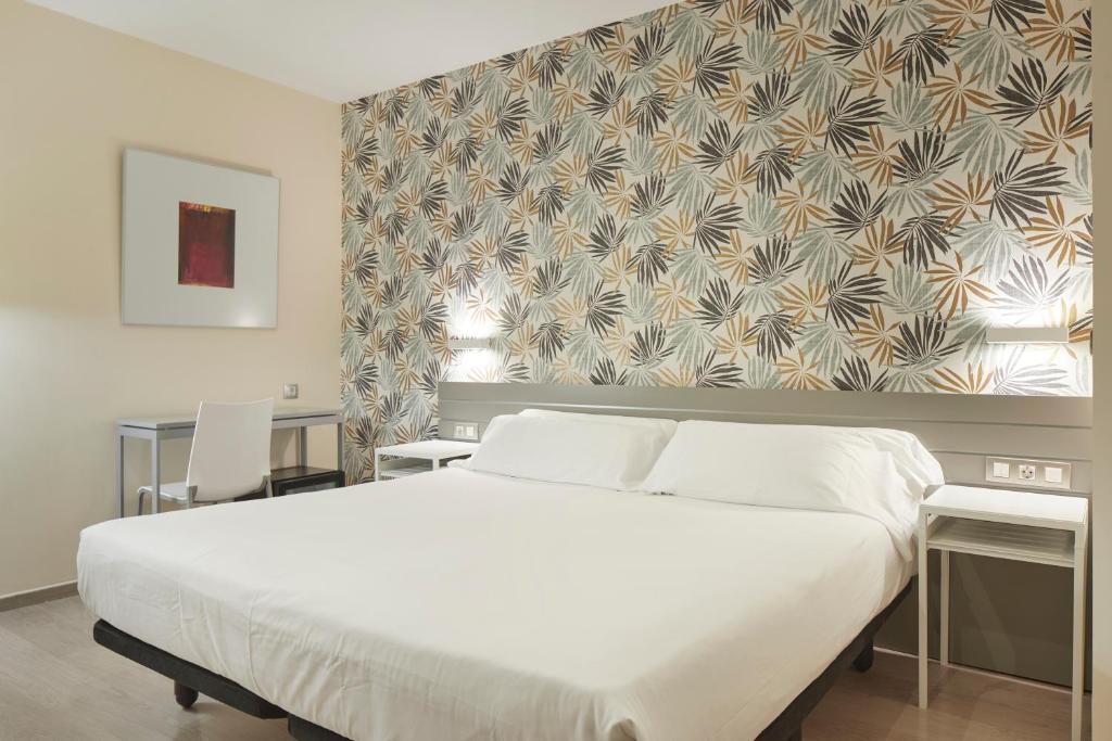 圣塞瓦斯蒂安格罗斯迎宾酒店的一间卧室设有一张大床和一个大窗户