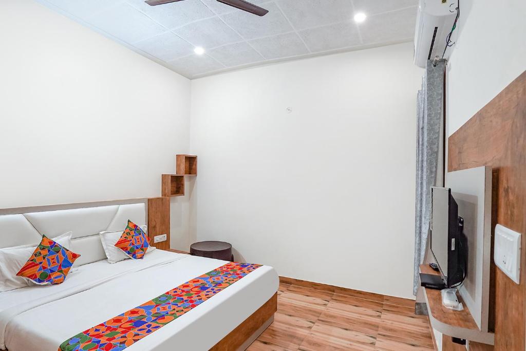阿格拉FabHotel Sirtaj Suites的一间卧室配有一张床和一台平面电视