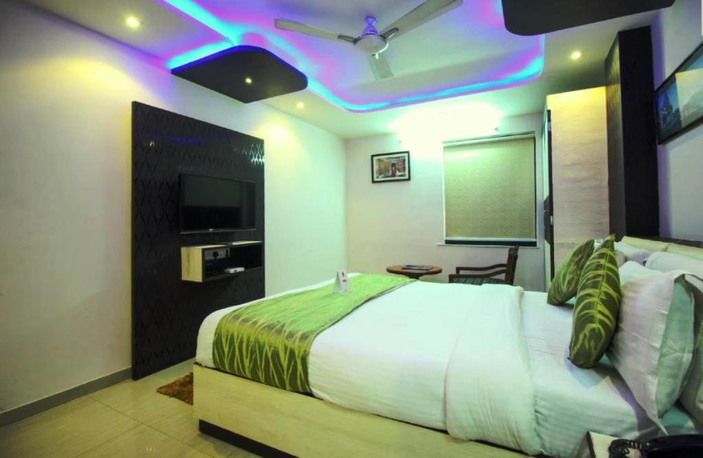 艾哈迈达巴德Hotel Sadbhav的一间卧室配有一张带绿色和白色棉被的床