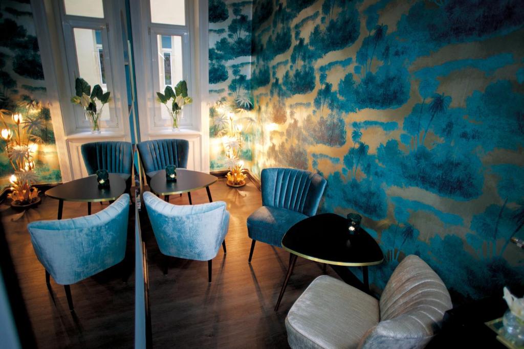 汉堡弗里茨普亚马酒店的一间设有两张桌子和蓝色椅子的房间