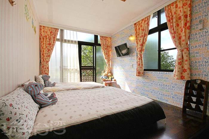 古坑華山禾園親子民宿的一间卧室设有两张床和窗户。