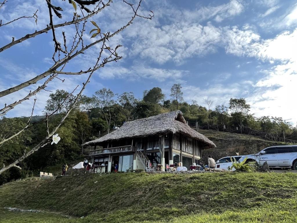 和平Mường Ecolodge Hòa Bình的山坡上草屋顶的房子