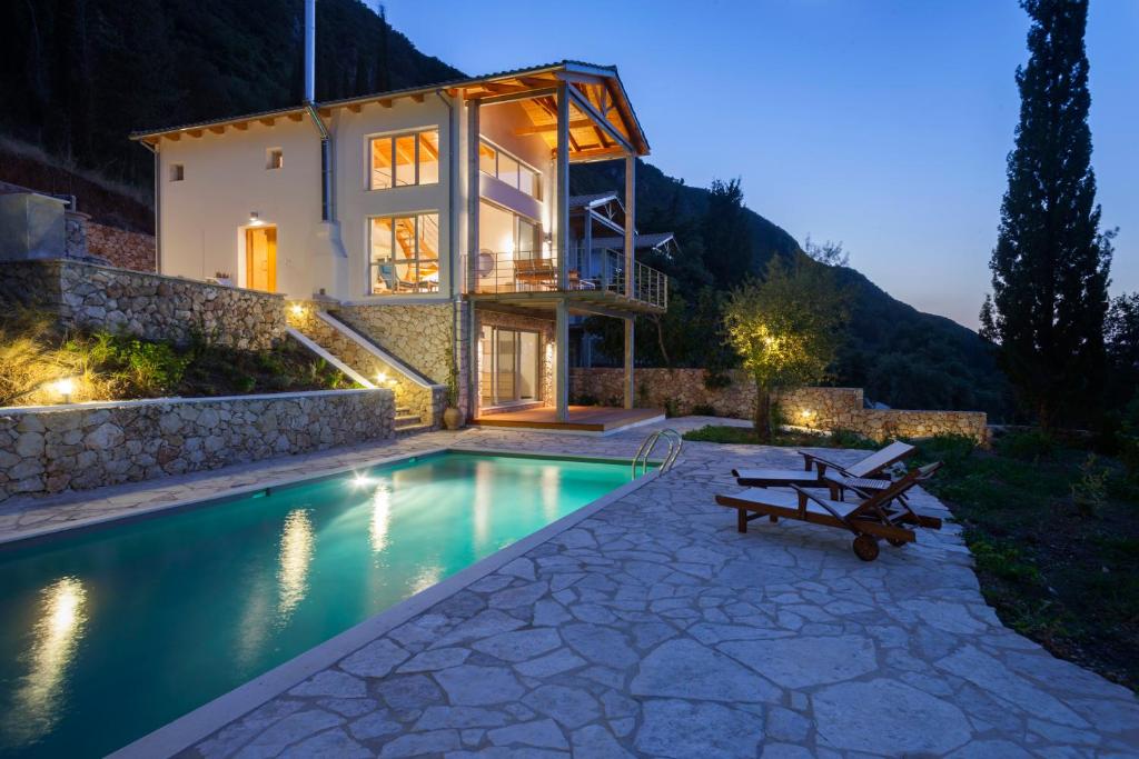 雷夫卡达镇Ionian Dream Villas的夜间带游泳池的别墅