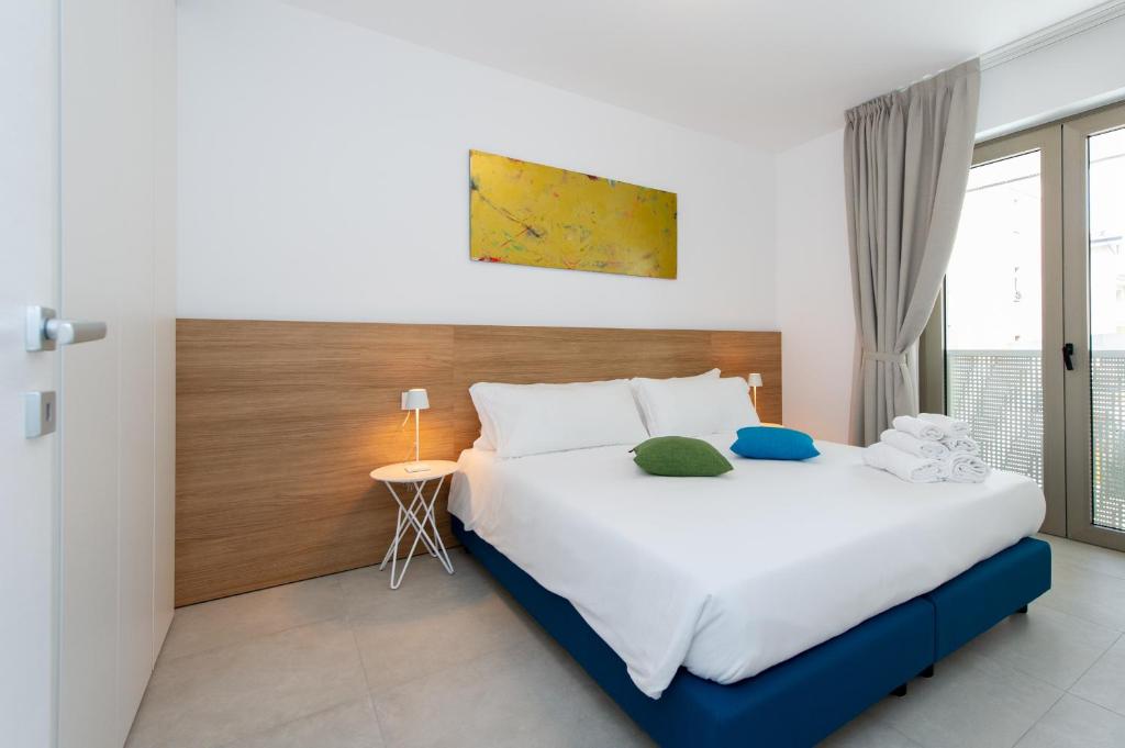 格拉多Ariston Teatro Luxury Aparthotel的一间卧室设有一张大床和一个窗户。