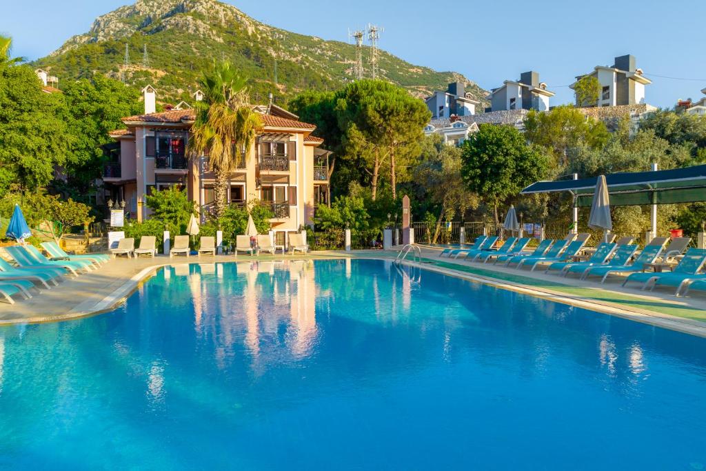 厄吕代尼兹粉红宫殿俱乐部酒店的一个带蓝色椅子的游泳池和一个山