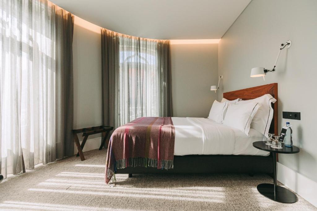 里斯本里斯本1908酒店的一间卧室设有一张床和一个大窗户
