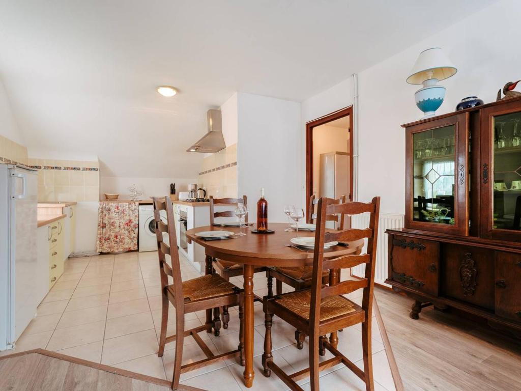 卡纳克Appartement Carnac, 3 pièces, 4 personnes - FR-1-477-100的厨房以及带木桌和椅子的用餐室。