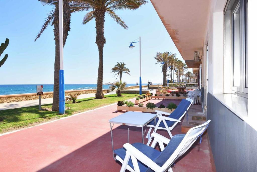 卡沃内拉斯precioso y moderno apartamento frente al mar的一个带桌椅和海滩的阳台