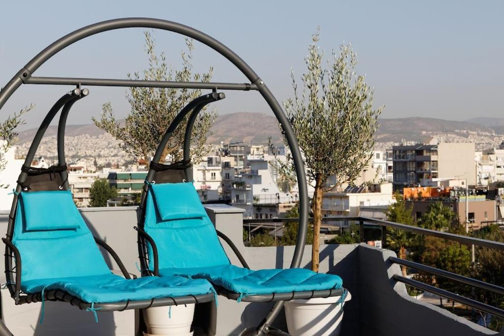 雅典Designer loft in heart of Athens nightlife的阳台上摆放着两把蓝色椅子