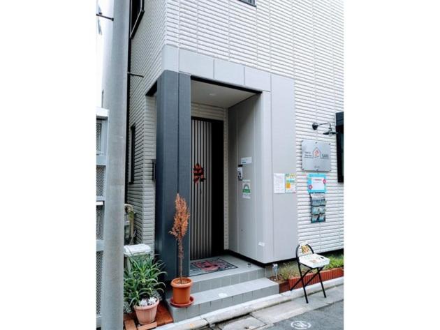 东京Tokyo stay Hut SARI - Vacation STAY 27260v的植物和椅子的建筑的门