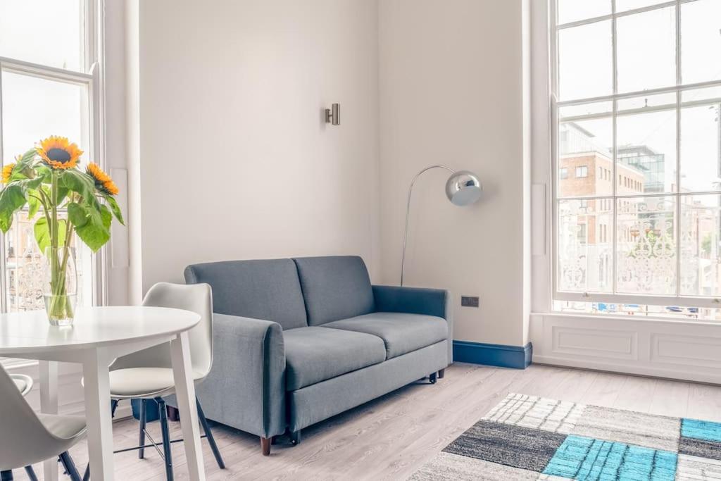 都柏林Central Dublin Apartment的客厅配有蓝色的沙发和桌子
