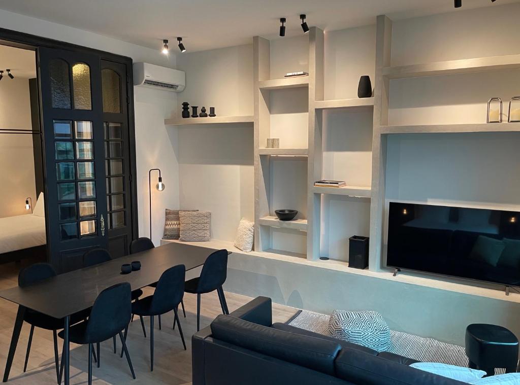 根特3 Bedroom Art-Nouveau Apartment with Free Parking的客厅配有桌椅和电视。