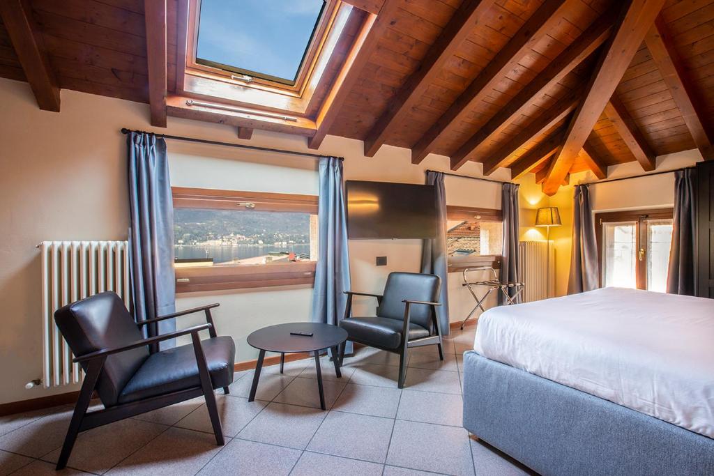 贝拉吉奥Antico Pozzo Apartment的一间卧室配有一张床、两把椅子和一个窗户