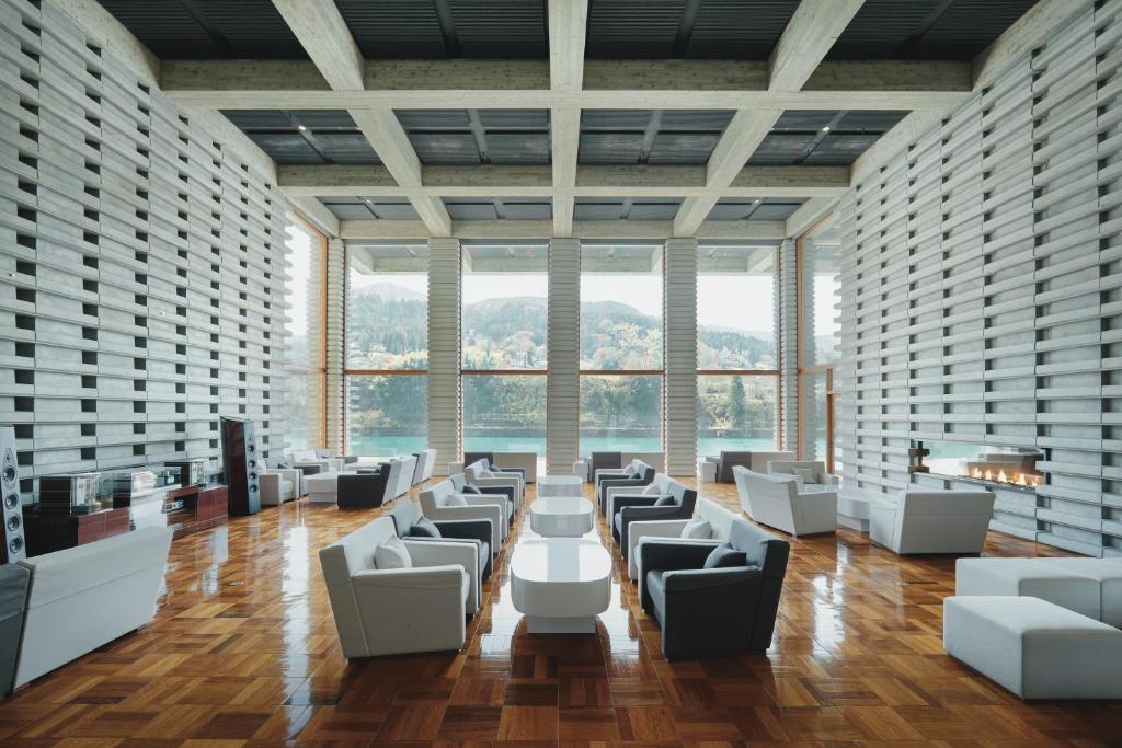 富山雅乐俱河景酒店的大房间设有白色的椅子、桌子和窗户