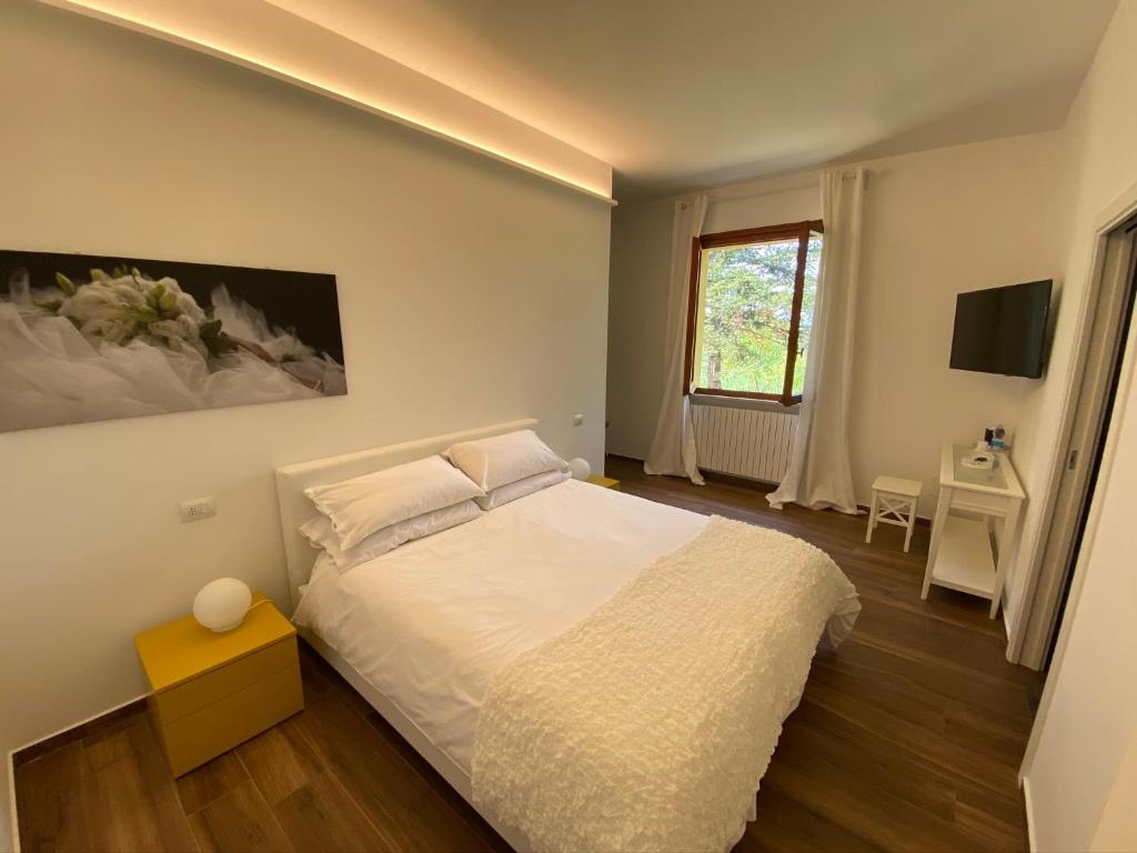 佩萨罗Villa Rina的卧室配有白色的床和窗户。
