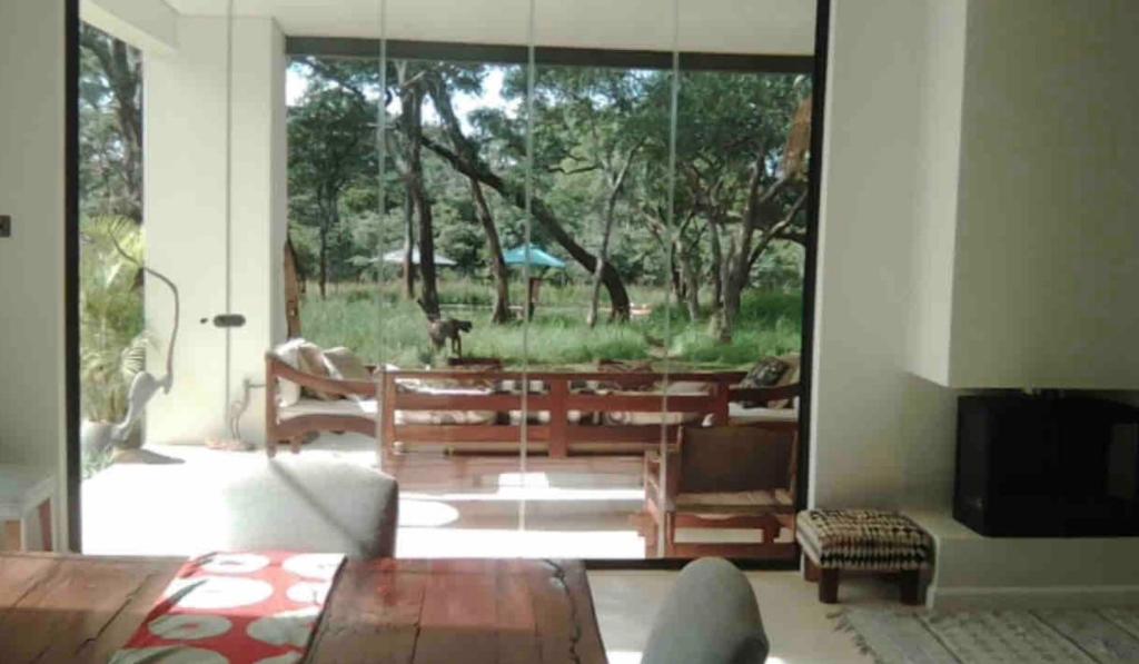 MwambulaLeopards Hill, Lusaka family home in beautiful nature的客厅外设有滑动玻璃门,带狗