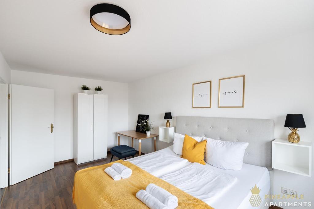 德累斯顿Pineapple Apartments Dresden Mitte III - free parking的白色卧室配有一张带黄色枕头的大床