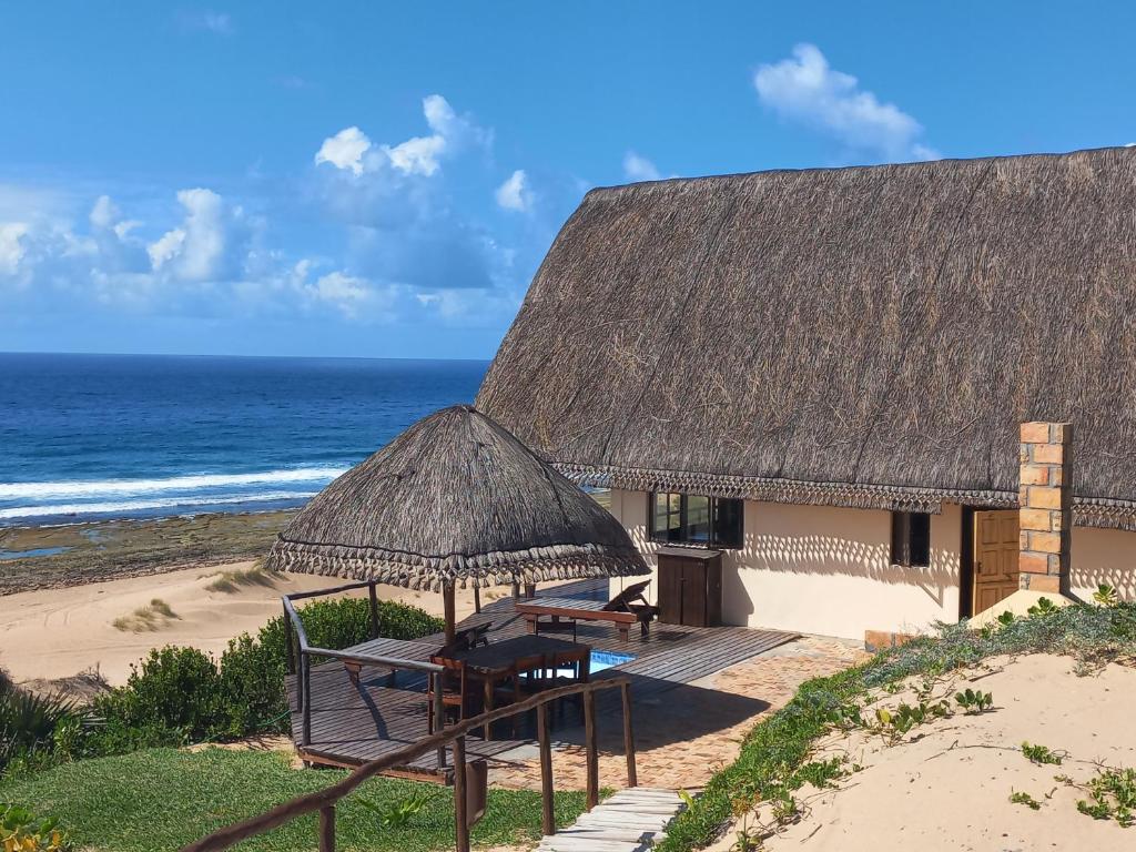 伊尼扬巴内Khumbula iMozambique的海滩上的小屋,配有桌椅和大海