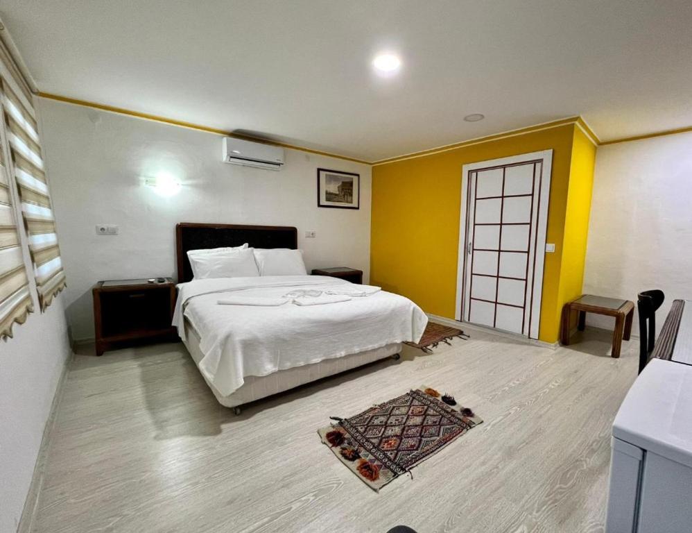 安塔利亚TAG Pansiyon的卧室设有白色的床和黄色的墙壁