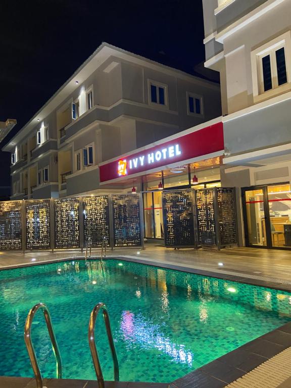 伊凯贾Ivy Hotel Emerald的夜间在酒店前的游泳池
