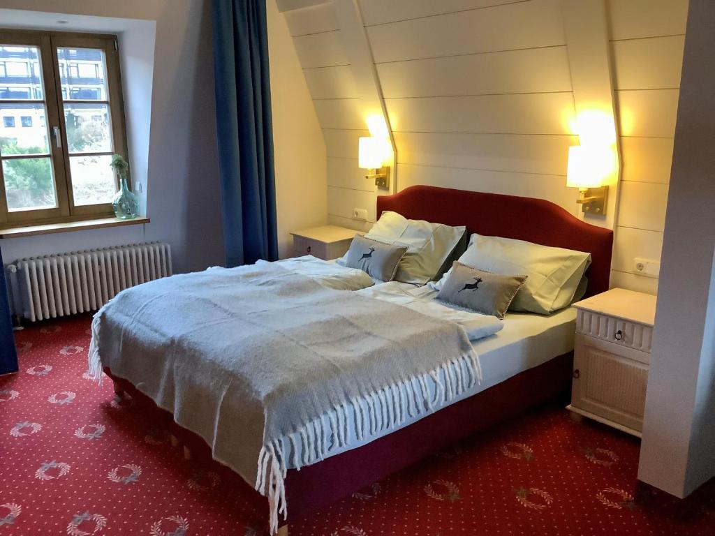 施坦贝尔格湖畔贝格Strandhotel Berg的一间卧室设有一张大床和一个窗户。