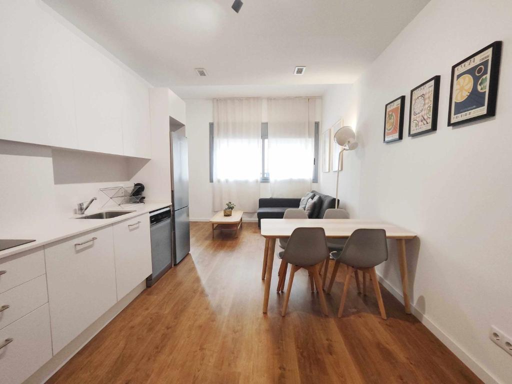 马塔罗Mazi Apartments Loft的厨房以及带桌椅的起居室。