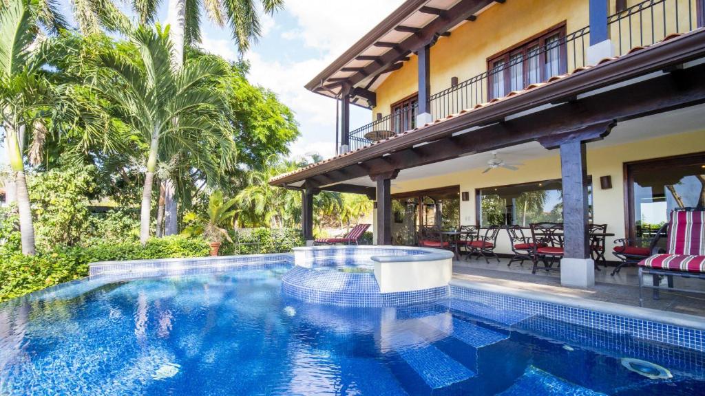 巴希利托Villa Zindagi Luxury Villa Private Pool - Reserva Conchal的棕榈树屋前的游泳池
