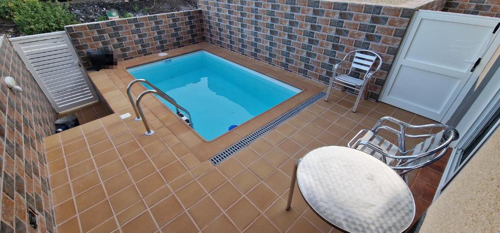 塔马达斯特VV EL OASIS的庭院中带桌椅的游泳池
