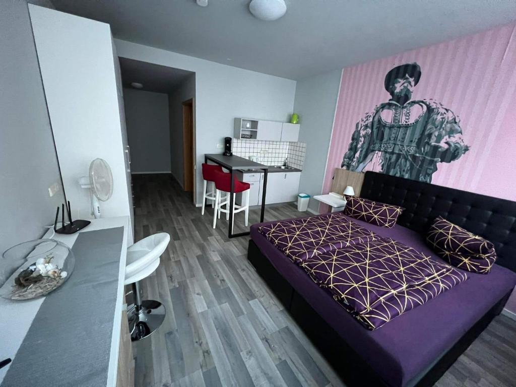斯图加特MIDTOWN Apartments的一间卧室配有一张紫色的床、一张桌子和一张书桌。