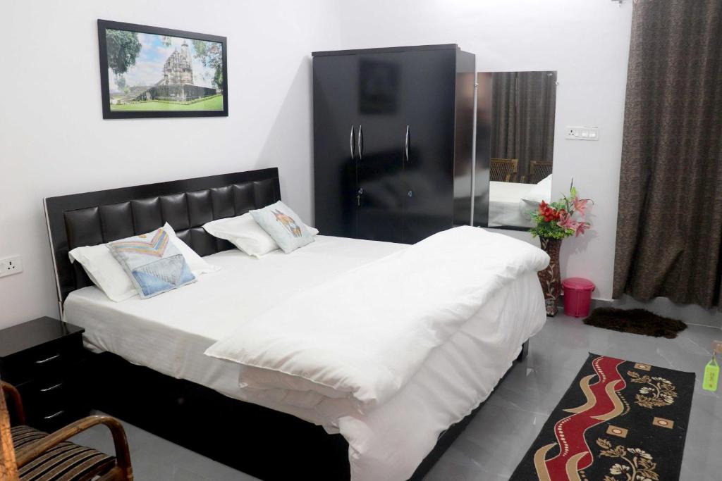 克久拉霍Khajuraho Glory Homestay的卧室配有一张带白色床单和枕头的大床。